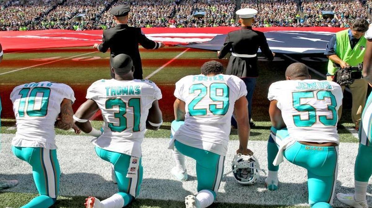 Miami Dolphins Kenny Stills, Michael Thomas, Arian Foster, and Jelani Jenkins, kneel in protest during the national athem as the Fins prepared to play the Seattle Seahawks at CenturyLink Field in Seattle, WA, on September 11, 2016.