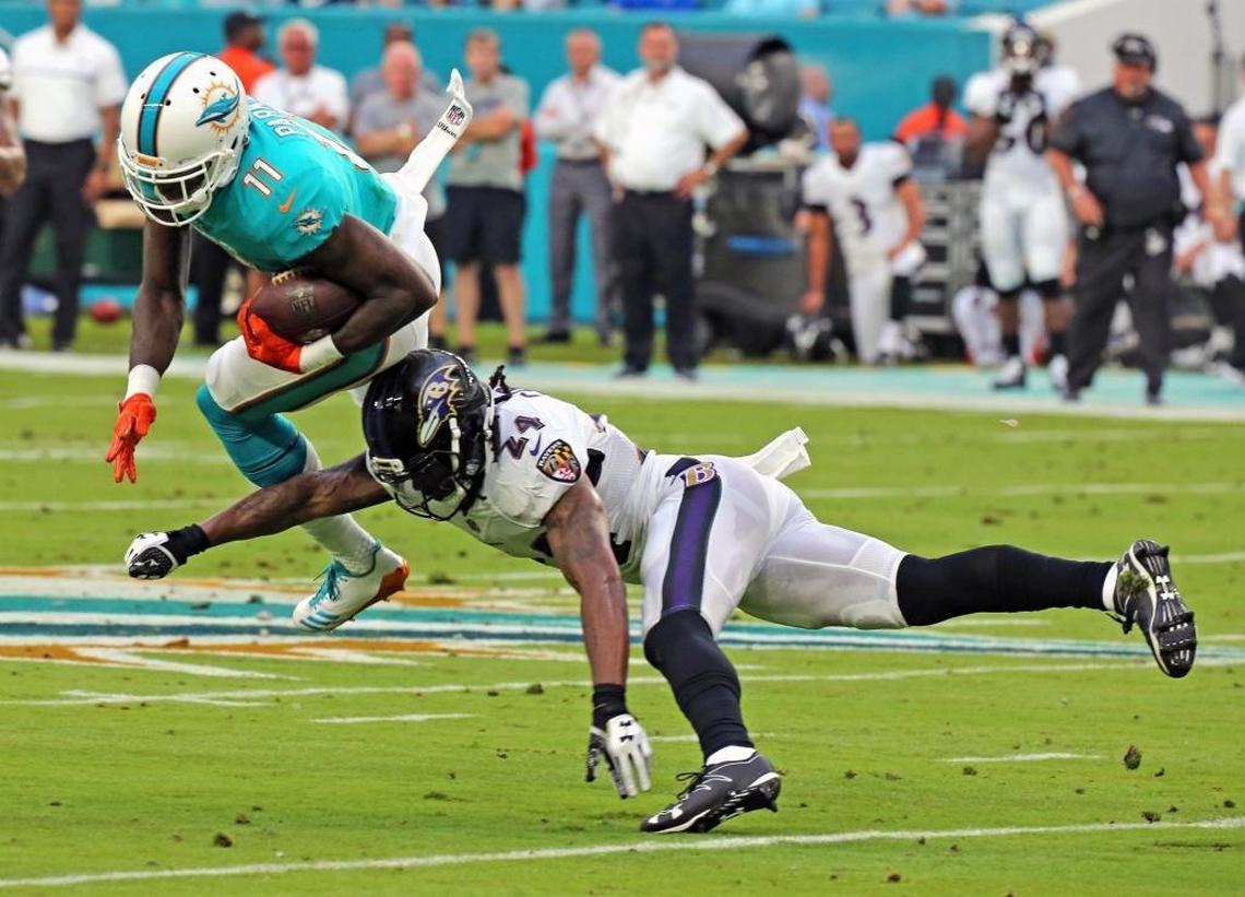 Dolphins DeVante Parker (11) gets hit by the Ravens Brandon carr (24) in the first quarter as the Miami Dolphins play the Baltimore Ravens in their second preseason game at Hard Rock Stadium in Miami Gardens, FL, Aug. 17, 2017.
