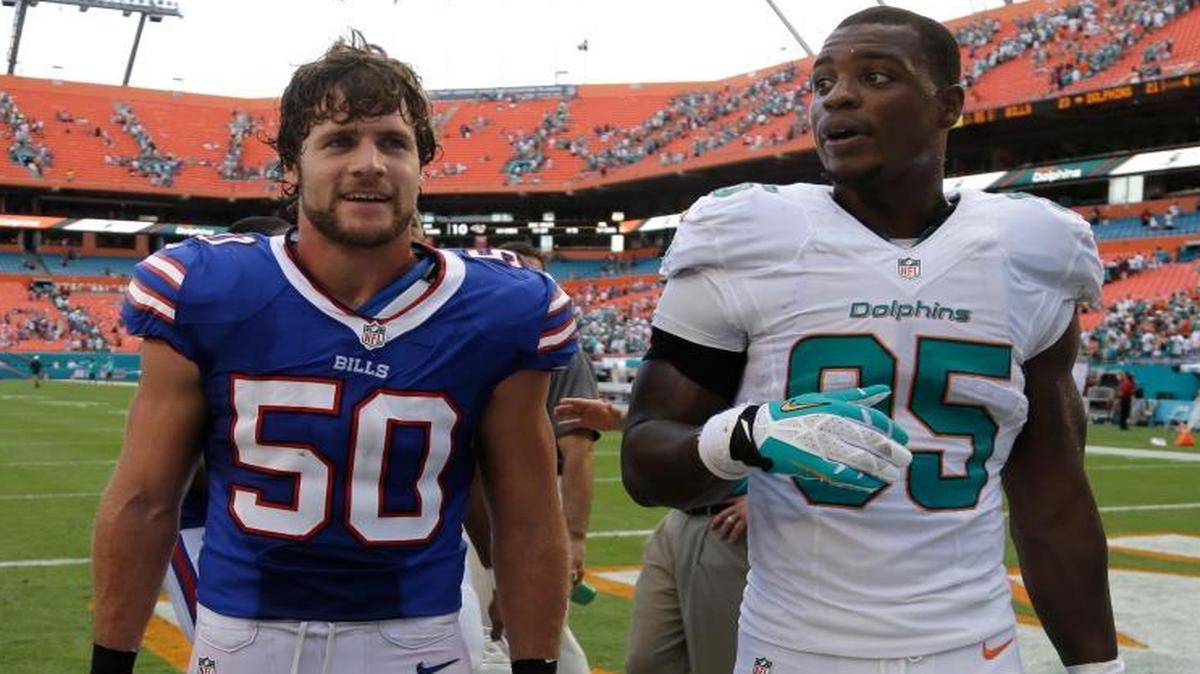 Buffalo Bills linebacker Kiko Alonso (50) and Miami Dolphins defensive end Dion Jordan (95) walk off the field after a game Sunday, Oct. 20, 2013, at Sun Life Stadium in Miami Gardens, Florida. Alonso and Jordan were teammates at the University of Oregon.