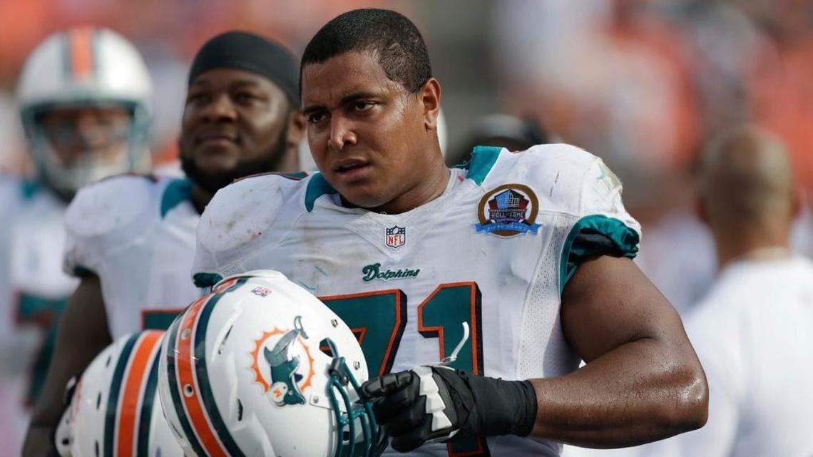 In this Dec. 16, 2012 file photo, Miami Dolphins tackle Jonathan Martin (71) watches from the sidelines during the second half of an NFL football game against the Jacksonville Jaguars, in Miami. Martin wants to return to the NFL, he said in an interview aired Wednesday where he claimed that racial, aggressive and sexually charged comments all played a role in his departure from the Dolphins.