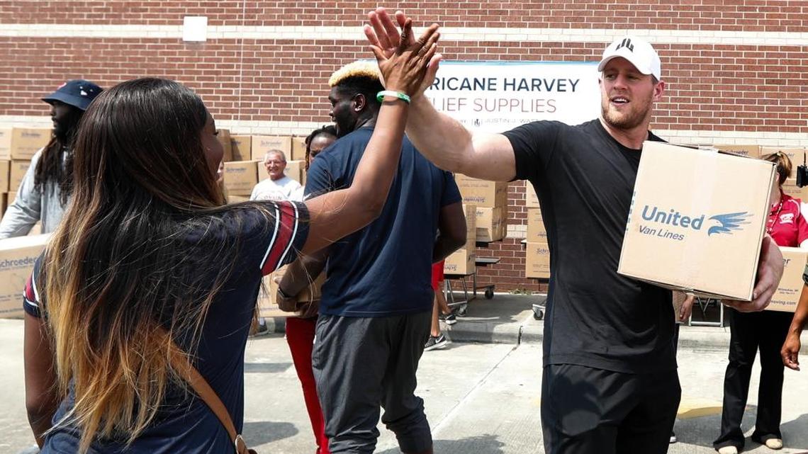 Houston defensive end J.J. Watt gives a high-five to Anna Ucheomumu after loading a car with relief supplies to people impacted by Hurricane Harvey on Sunday. Watt's Hurricane Harvey Relief Fund has raised close to $20 million to help those affected by the storm.