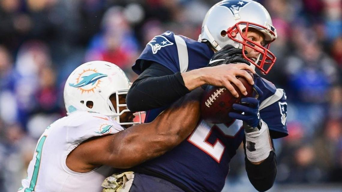 Tom Brady of the New England Patriots is sacked by Cameron Wake of the Miami Dolphins during the fourth quarter of a game at Gillette Stadium on Nov. 26, 2017 in Foxboro, Massachusetts.