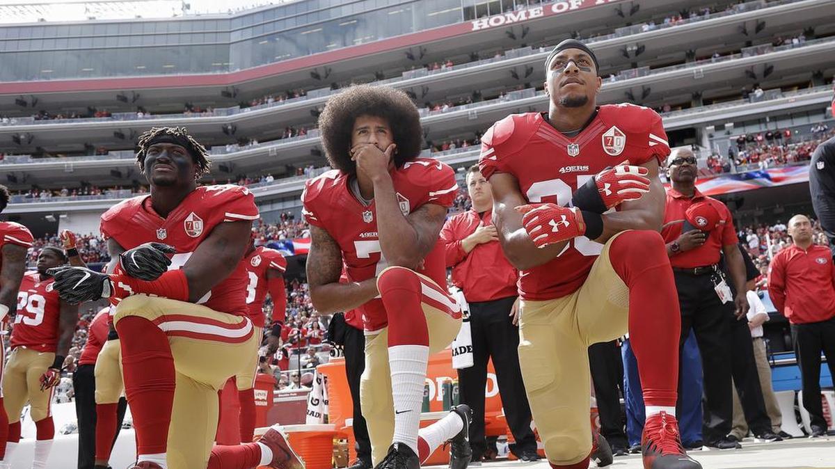 Colin Kaepernick, center, is flanked by San Francisco teammates Eli Harold and Eric Reid as they kneel in protest during the national anthem before a game against the Dallas Cowboys in October.