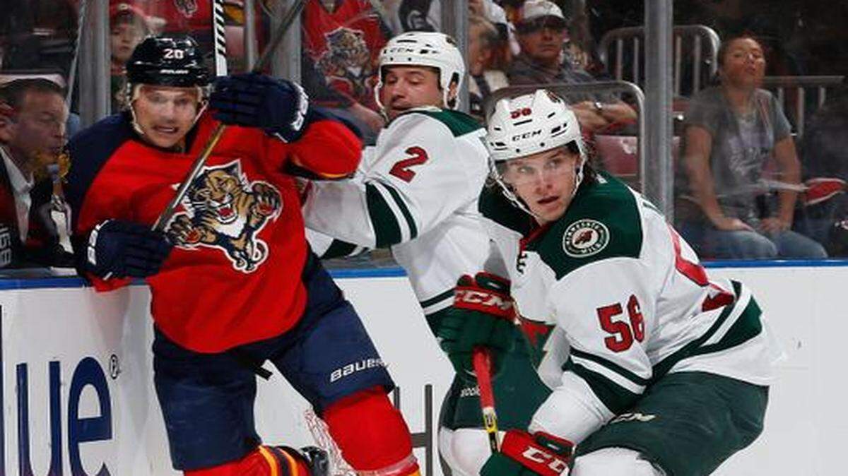 
The Wild’s Erik Haula skates away with the puck after teammate Keith Ballard checks the Panthers’ Sean Bergenheim into the boards.

