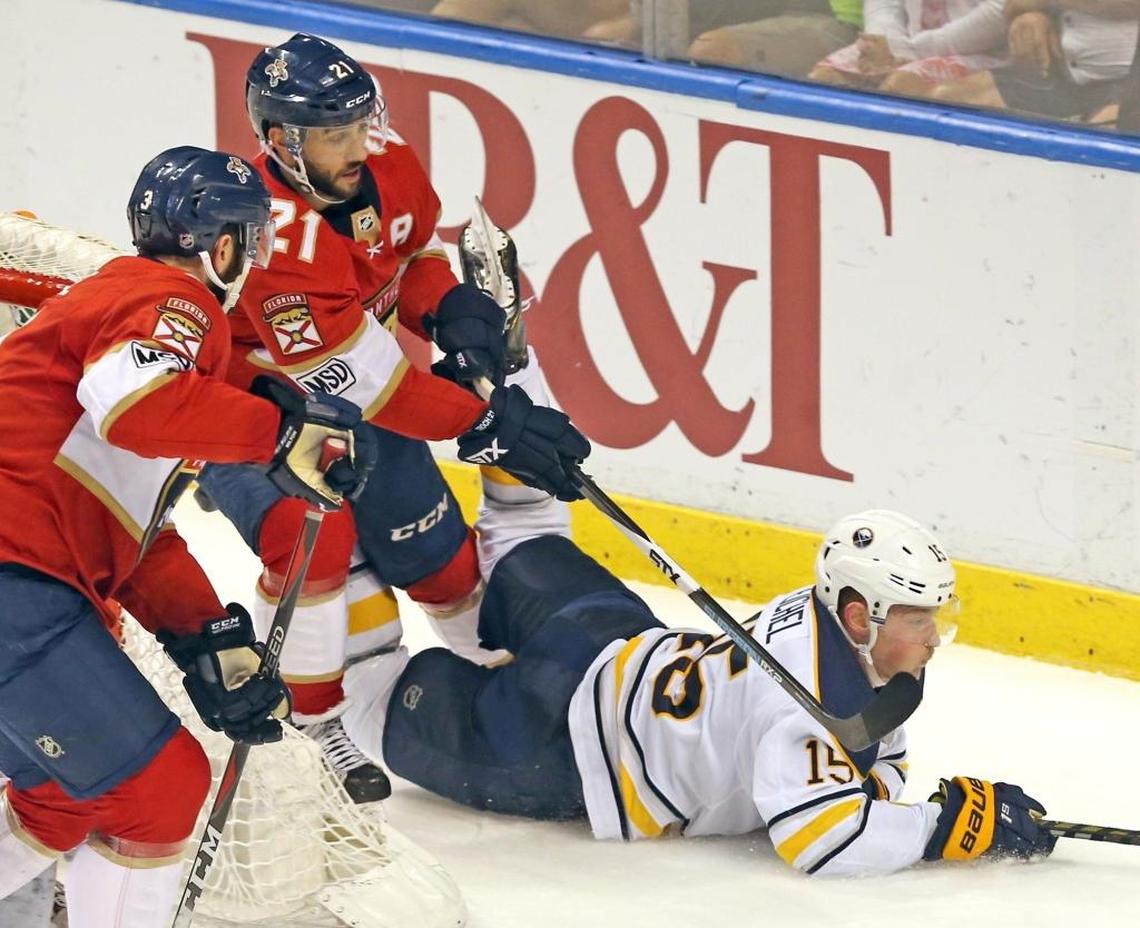 Florida Panthers’ Vincent Trocheck (21) reaches around Buffalo Sabres’ Jack Eichel (15) as he slides on the ice in the first period Saturday, April 7, 2018, at the BB&T Center in Sunrise, Fla.