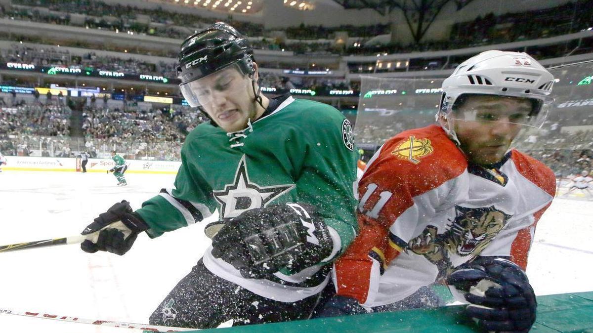Florida Panthers center Jonathan Huberdeau (11) and Dallas Stars defenseman Jamie Oleksiak (5) crash into the boards during the first period of an NHL hockey game Saturday, Oct. 24, 2015, in Dallas.