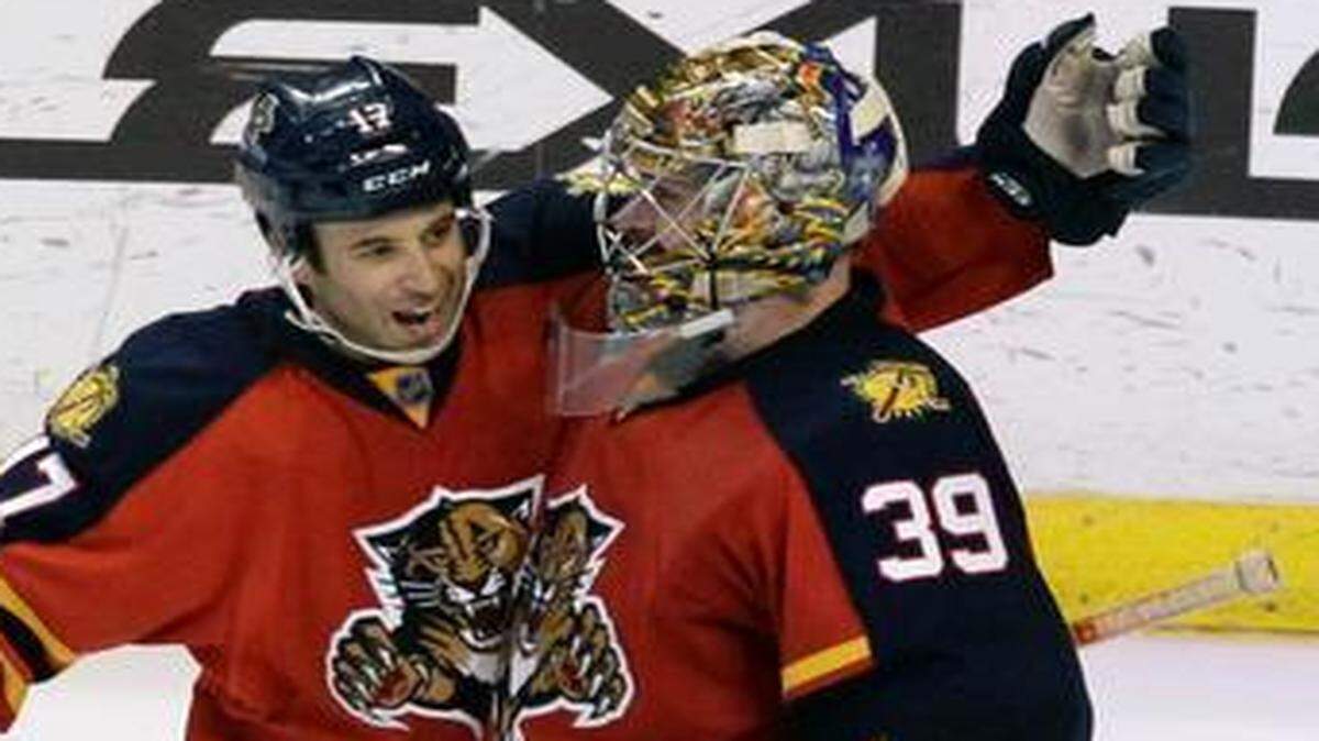 
Florida Panthers goalie Dan Ellis (39) celebrates with Derek Mackenzie after the Panthers defeated the New York Islanders 4-3 in a shootout Saturday, March 7, 2015, in Sunrise, Fla.

