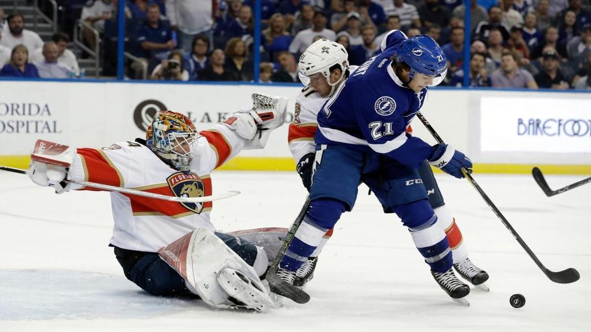 Tampa Bay Lightning center Brayden Point (21) and Florida Panthers's Jonathan Marchessault (81) battle for the puck in front of Panthers goaltender James Reimer (34) during the second period of an NHL hockey game Tues., Oct. 18, 2016, in Tampa, Fla.