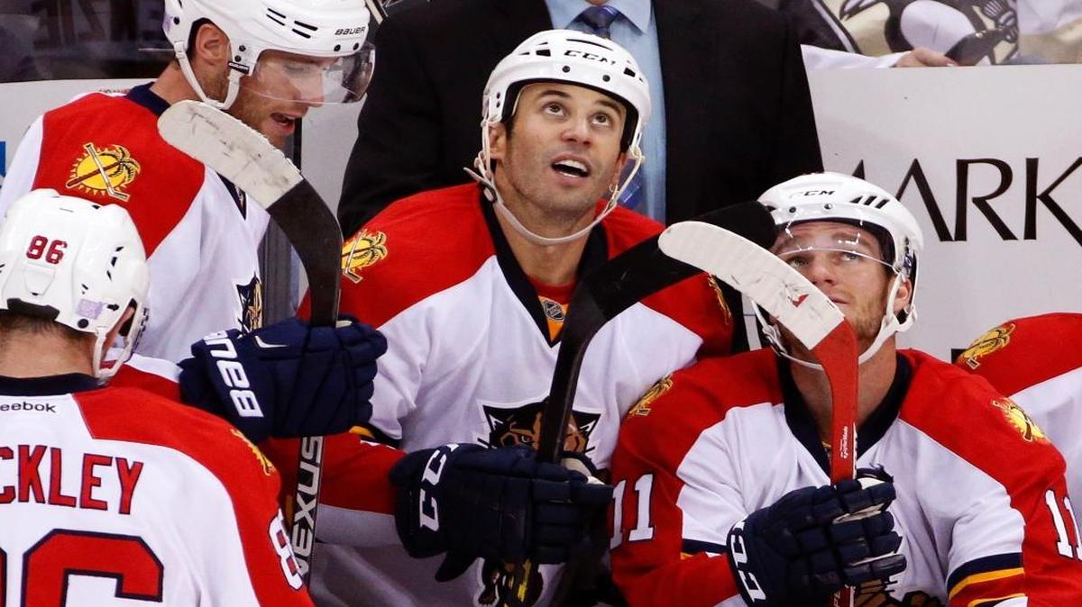 Florida Panthers' Derek MacKenzie, center, watches a replay of his goal in the third period of an NHL hockey game against the Pittsburgh Penguins in Pittsburgh, Tuesday, Oct. 20, 2015. The Penguins won in overtime, 3-2.