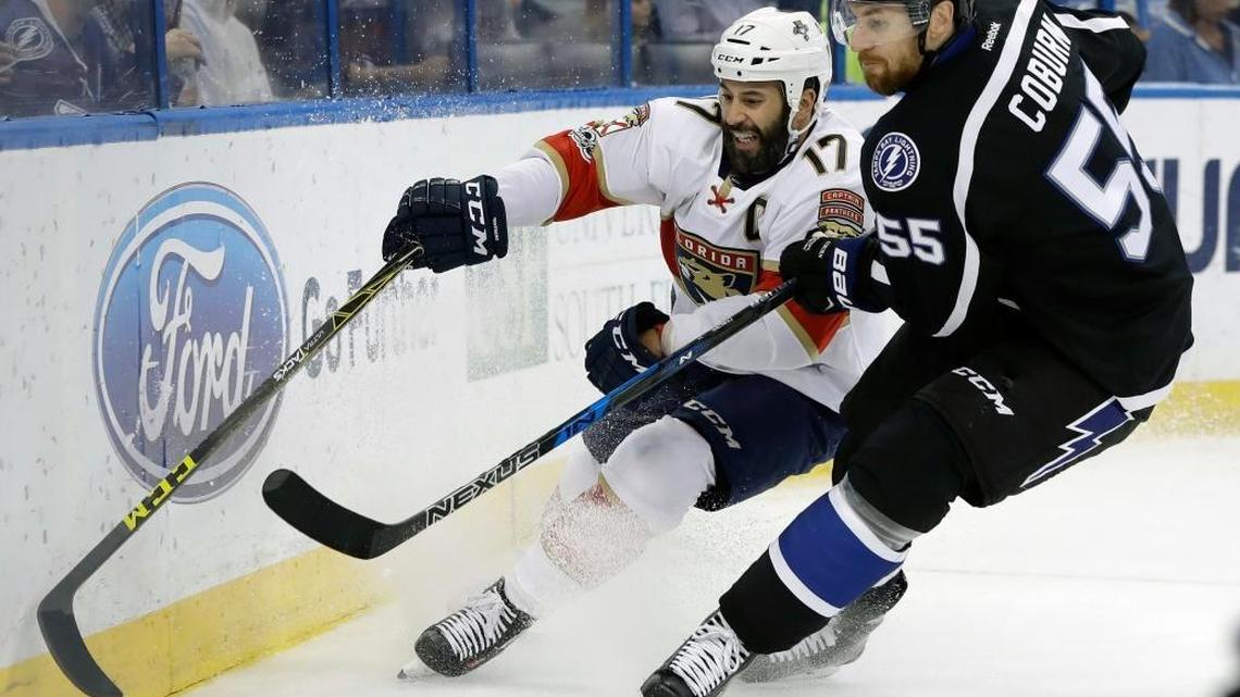 Tampa Bay Lightning defenseman Braydon Coburn (55) forces Florida Panthers center Derek MacKenzie (17) into the boards as they chase a loose puck during the first period of an NHL hockey game, Saturday, March 11, 2017, in Tampa, Fla.