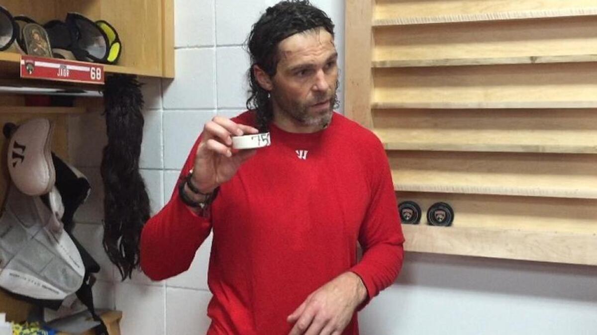 Jaromir Jagr poses with the puck he scored his 750th NHL goal with on Thursday night in the Florida locker room.