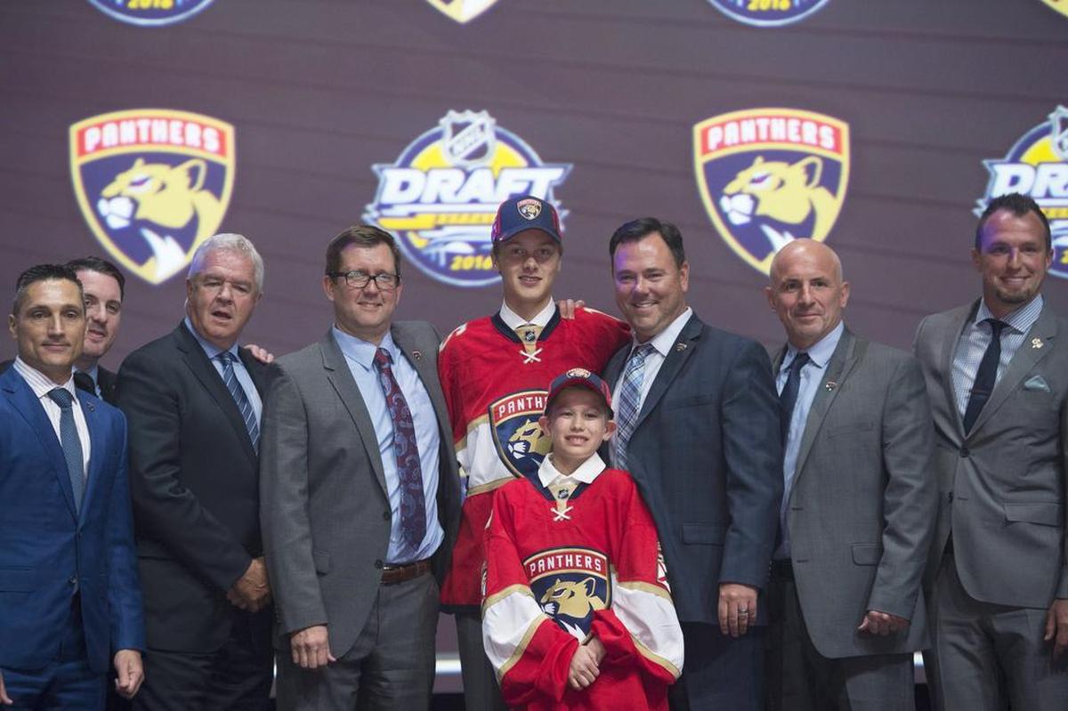 Henrik Borgstrom, center, stands on stage with members of the Florida Panthers management team at the NHL hockey draft on June 24, 2016, in Buffalo, New York.