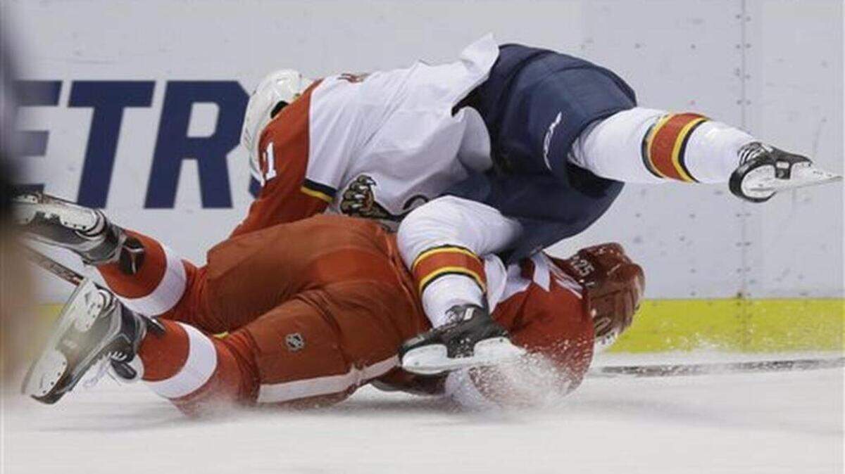 Florida Panthers center Jonathan Huberdeau, top, checks Detroit Red Wings defenseman Mike Green during the first period of an NHL hockey game, Sunday, Nov. 29, 2015, in Detroit.