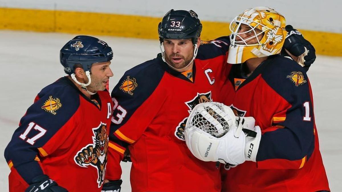 Florida Panthers goaltender Roberto Luongo (1) is congratulated by forward Derek MacKenzie (17) and defenseman Willie Mitchell (33) at the end of an NHL hockey game against the Columbus Blue Jackets, Sunday, Dec. 27, 2015, in Sunrise, Fla. The Panthers defeated the Blue Jackets 3-2.