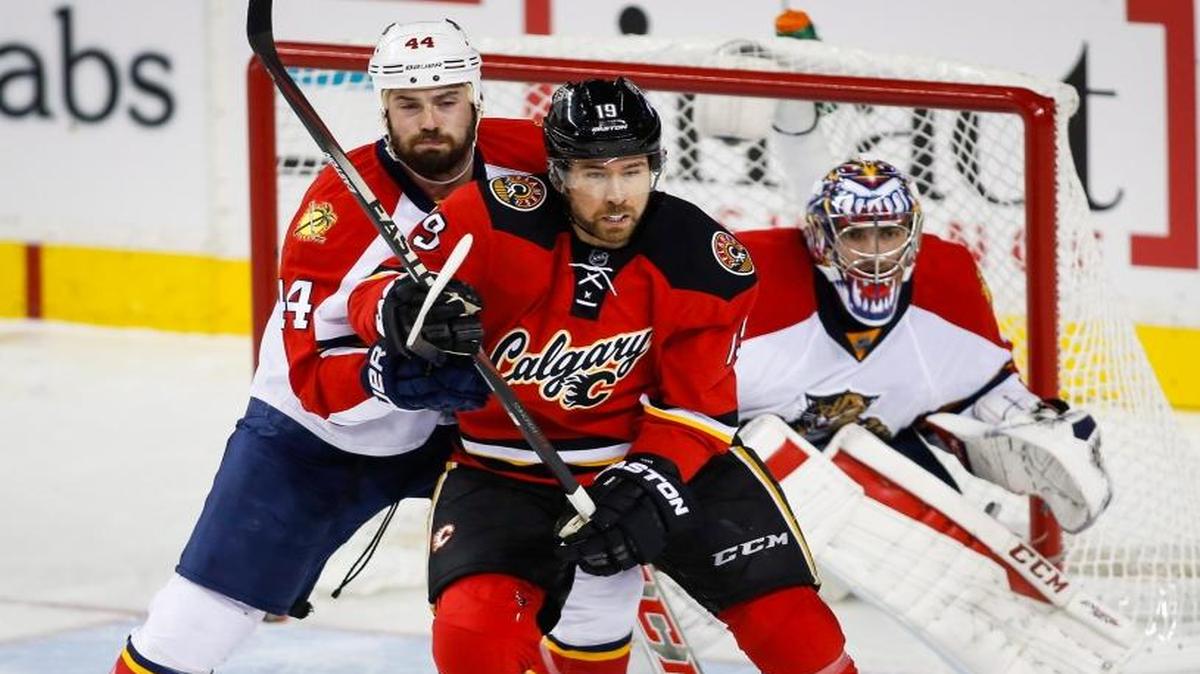 Florida Panthers’ Erik Gudbranson, left, and Calgary Flames’ David Jones, center, tangle as Panthers goalie Al Montoya watches during the second period of an NHL hockey game Wednesday, Jan. 13, 2016, in Calgary, Alberta.