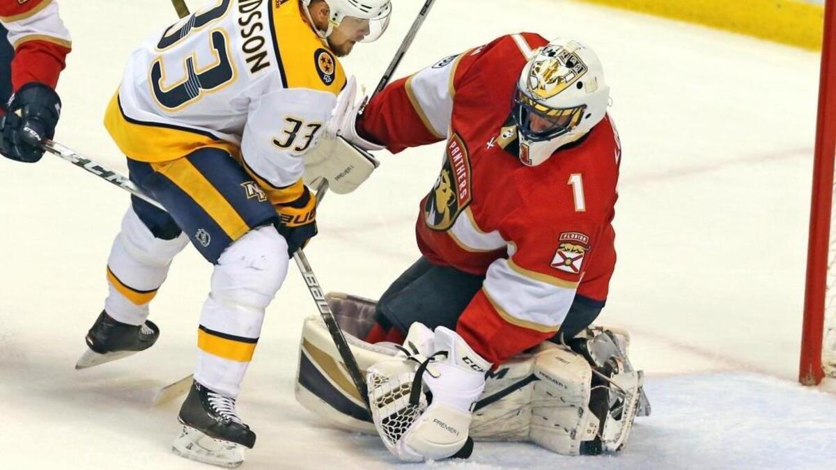 Florida Panthers goalie Roberto Luongo (1) holds the puck in his glove as Nashville Predators Viktor Arvidsson (33) pushes the puck into the goal to assit a disallowed goal by Predators Filip Forsberg (9) in the final seconds of the game at the BB&T Center in Sunrise on April 3, 2018. The officials ruled no goal.