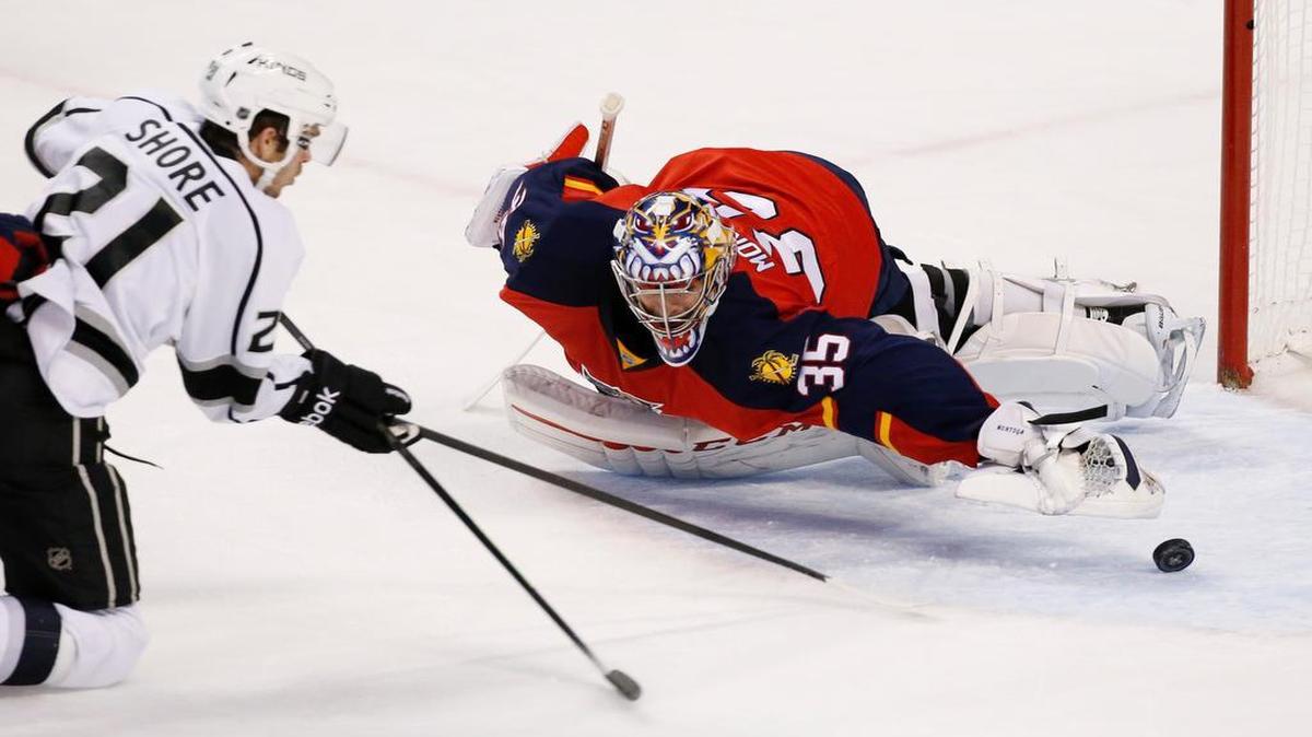 Panthers goalie Al Montoya dives for the puck hit by Kings center Nick Shore during the first period Monday night.