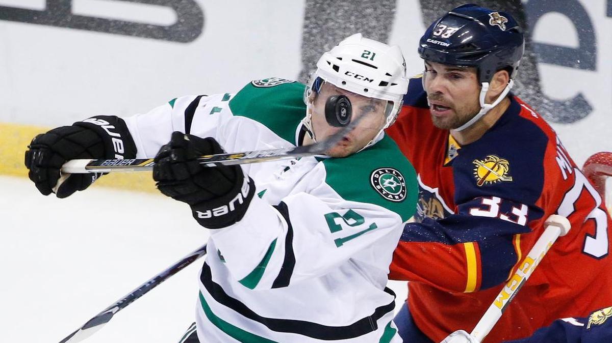
Stars left wing Antoine Roussel, left, bats the puck while being checked by Panthers defenseman Willie Mitchell in Saturday’s game.
