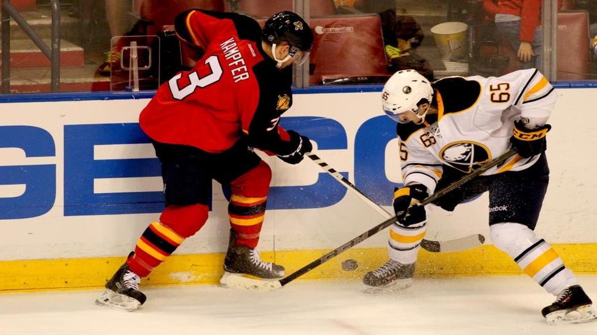 The Panther's Steven Kampfer (#3), left, fights for the puck against the Buffalo Sabre's Brian Flynn (#65), right, on Saturday, February 28, 2015.