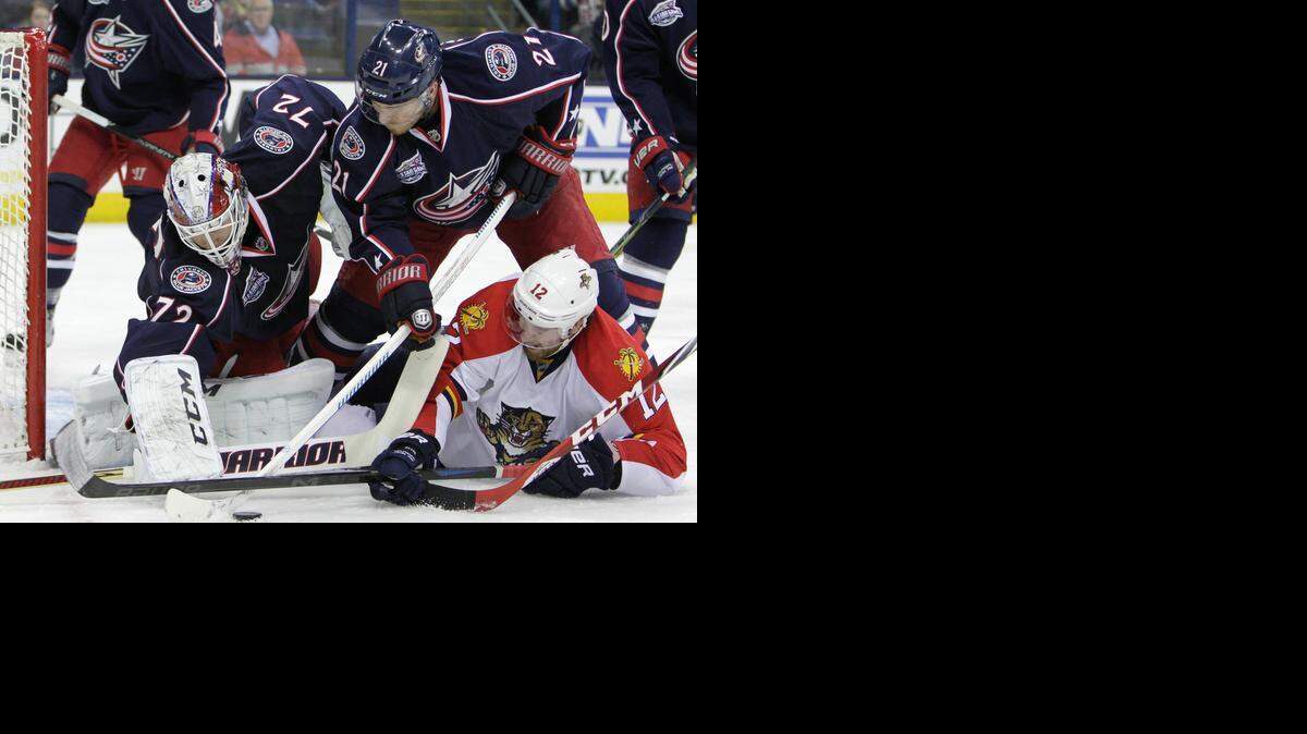
Blue Jackets goalie Sergei Bobrovsky makes a save as the Panthers’ Jimmy Hayes, right, tries to fight for a rebound during Monday night’s game. Bobrovsky improved to 7-1 against the Panthers.
