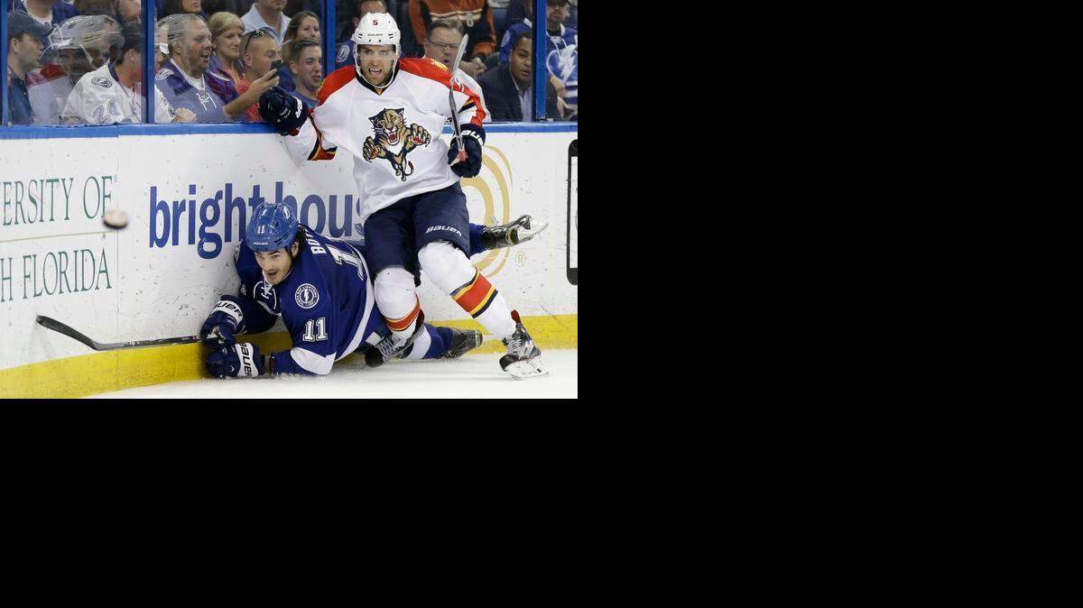 
Florida Panthers defenseman Aaron Ekblad (5) takes down Tampa Bay Lightning center Brian Boyle (11) as the puck skips away during the second period of an NHL hockey game Tuesday, March 24, 2015, in Tampa, Fla.
