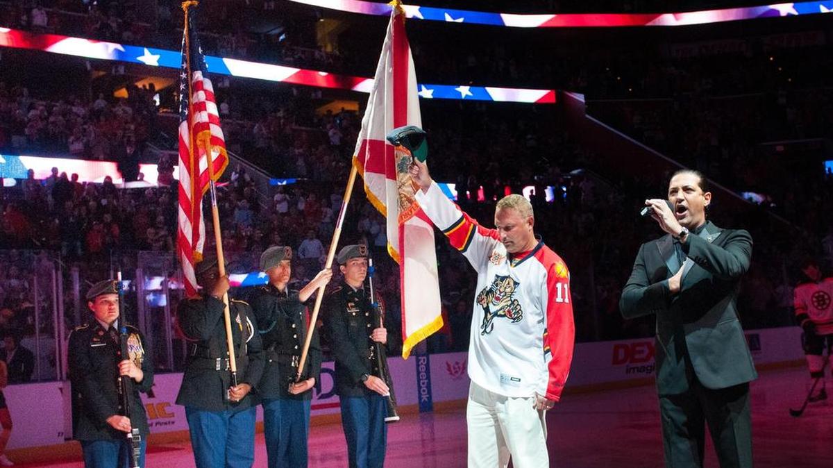 U.S. Navy Fire Controlman Second-Class Bill Davis stands on the ice next to Ghaleb Emachah, who is singing the National Anthem before the Panthers-Bruins game at BB&T Center on Oct. 30. Emachah beat out close to 30 other singers in auditions to perform at Florida Panthers hockey games.