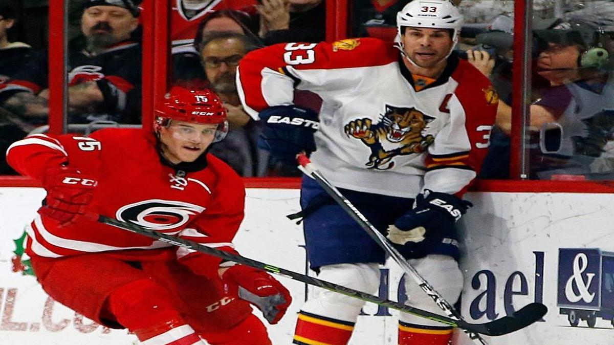 Carolina Hurricanes’ Andrej Nestrasil (15) chases the pass of Florida Panthers’ Willie Mitchell (33) during the second period Friday, Dec. 18, 2015, in Raleigh, N.C. Florida won 2-0.