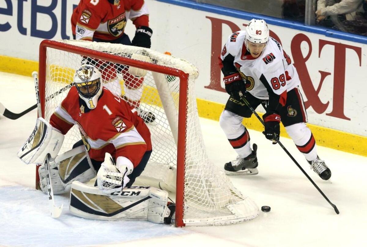 Florida Panthers goalie Roberto Luongo prepares to defend the goal as Ottawa Senators Max McCormick brings the puck around the net at the BB&T Center in Sunrise, Florida, March 12, 2018.