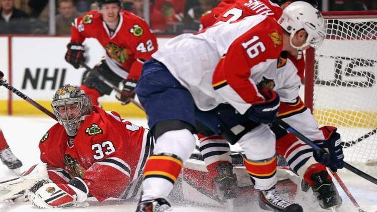 
Scott Darling #33 of the Chicago Blackhawks dives to make a save against Aleksander Barkov #16 of the Florida Panthers at the United Center on February 24, 2015 in Chicago, Illinois. 

