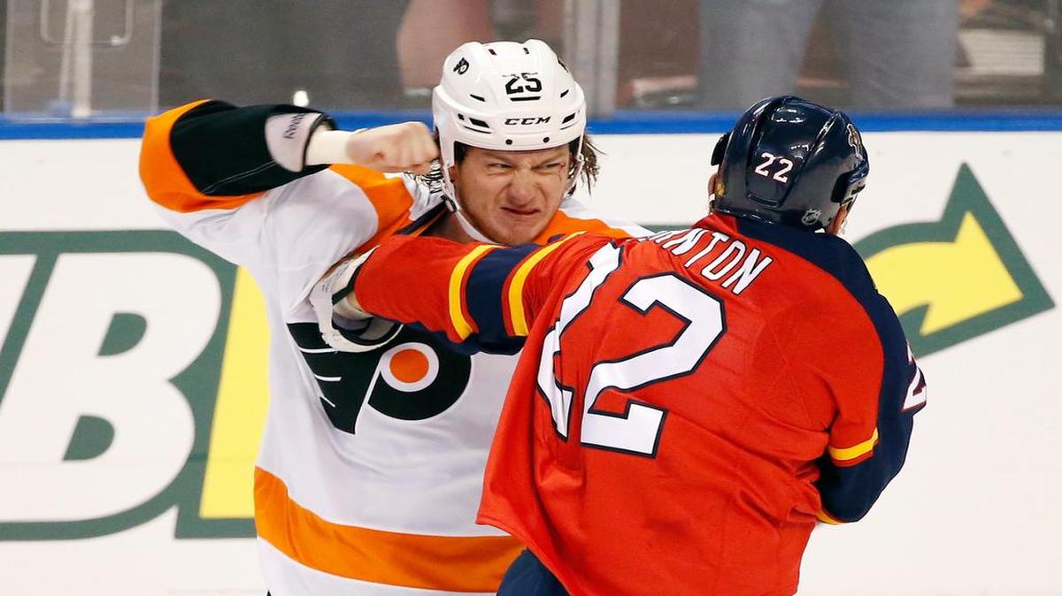 
Flyers center Ryan White, left, fights Saturday with Panthers right wing Shawn Thornton, who might have been playing in the final season opener of his career.
