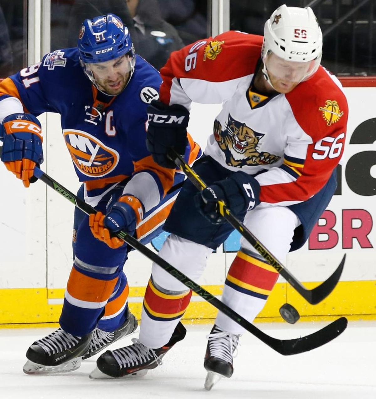 New York Islanders center John Tavares (91) tries to get the puck from Florida Panthers defenseman Michael Matheson (56) in the second period of Game 6 of an NHL hockey first-round Stanley Cup playoff series in New York, Sunday, April 24, 2016.