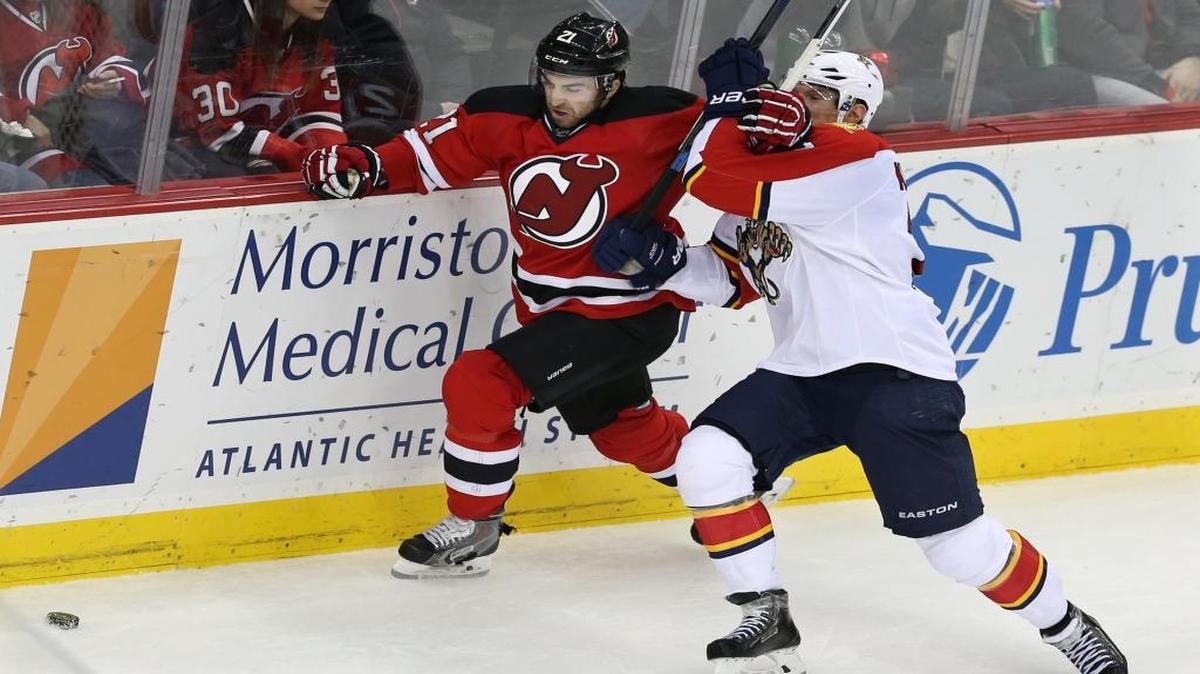 New Jersey Devils right wing Kyle Palmieri (21) hits Florida Panthers defenseman Dmitry Kulikov, of Russia, (7) as they chase a loose puck during the second period of an NHL hockey game, Sunday, Dec. 6, 2015, in Newark, N.J.