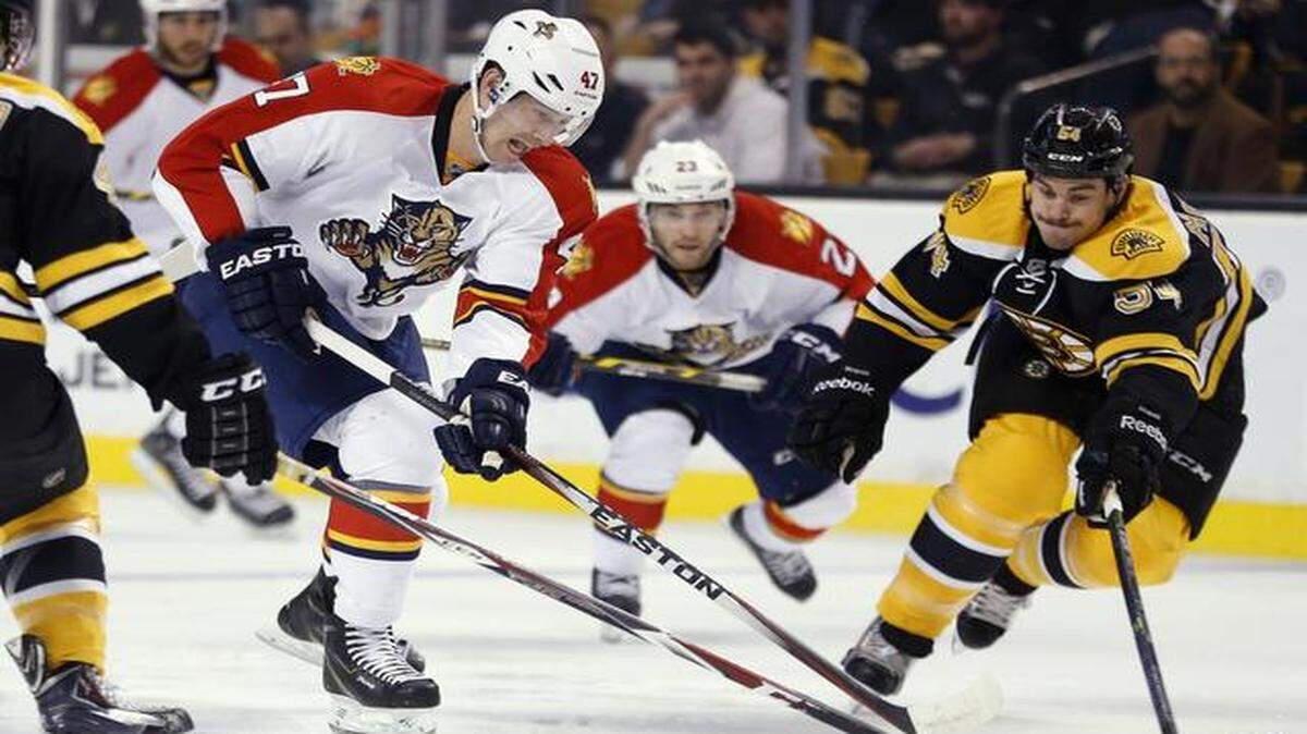 
Florida Panthers' Colby Robak (47) and Boston Bruins' Adam McQuaid (54) battle for the puck in the first period of an NHL hockey game in Boston, Tuesday, Nov. 4, 2014. 
