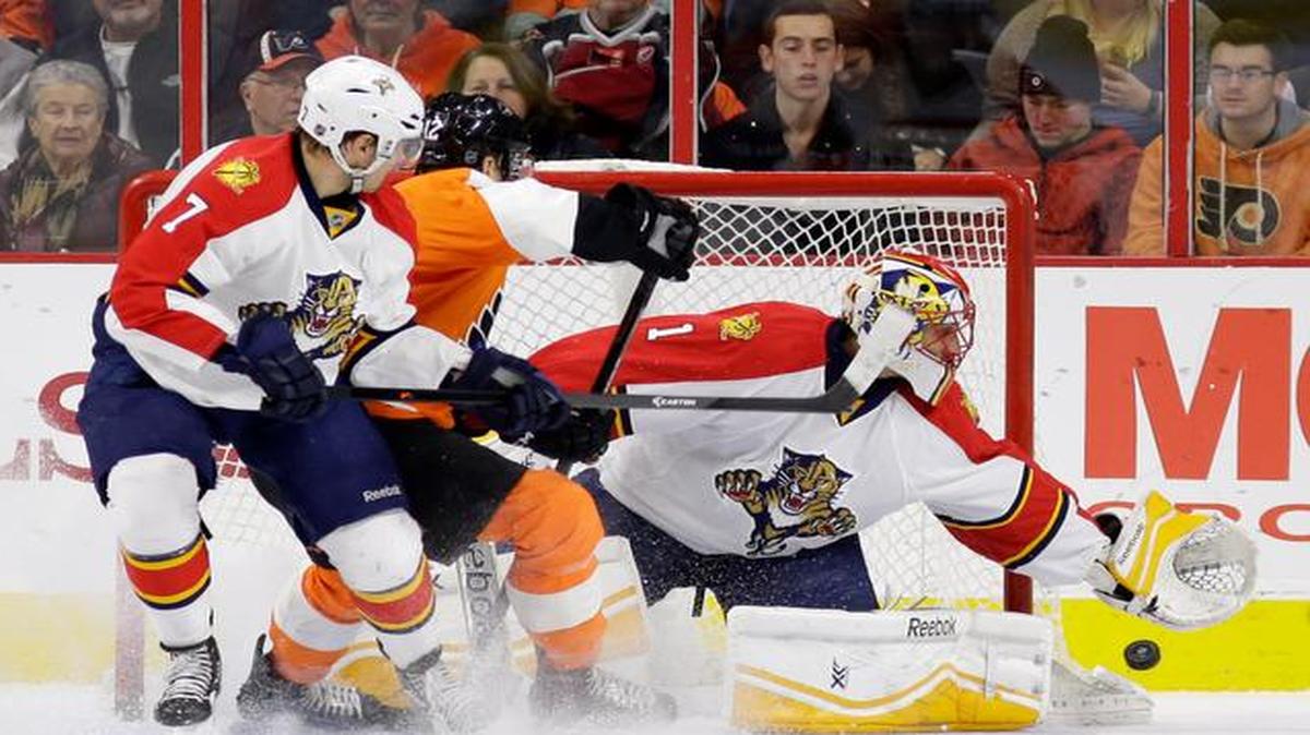 
Florida Panthers' Roberto Luongo, right, reaches for a wide shot as Philadelphia Flyers' Michael Raffl, center, of Austria, and Dmitry Kulikov, of Russia, look on during the first period of an NHL hockey game, Thursday, Dec. 18, 2014, in Philadelphia. 
