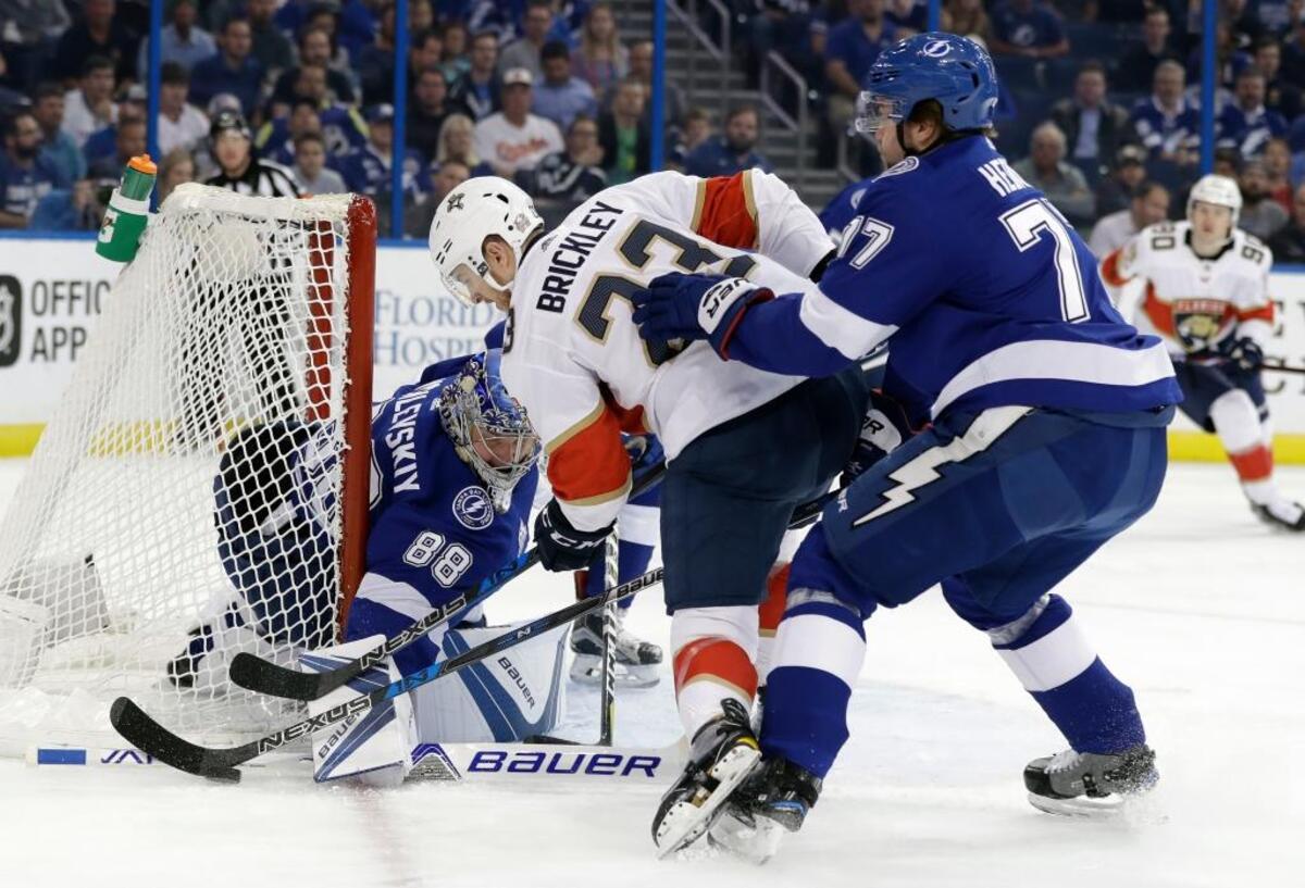 Florida Panthers center Connor Brickley (23) tries to stuff the puck past Tampa Bay Lightning goaltender Andrei Vasilevskiy, (88), of Russia, as defenseman Victor Hedman, (77), of Sweden, defends during the first period of an NHL hockey game Tuesday, March 6, 2018, in Tampa, Fla.