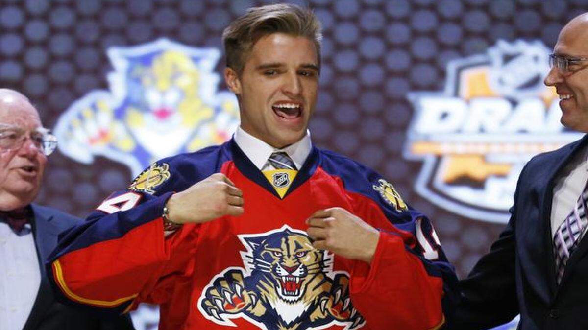 
Aaron Ekblad pulls on a Florida Panthers sweater after being chosen first overall in the NHL hockey draft, Friday, June 27, 2014, in Philadelphia. 

