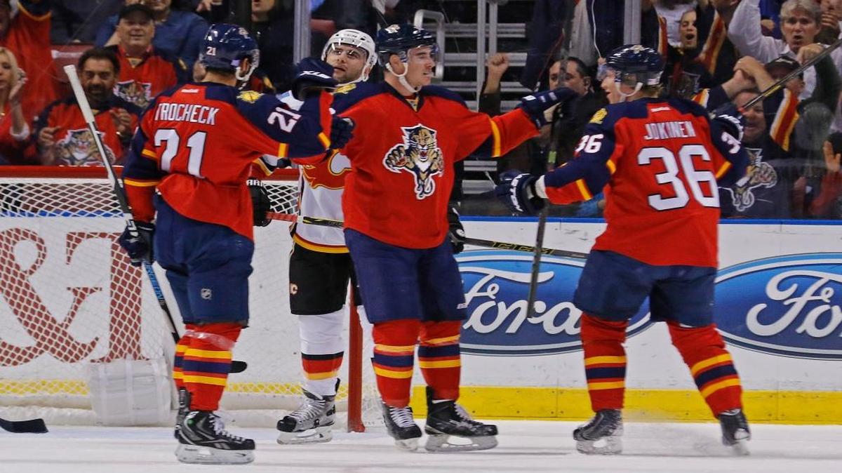 Florida Panthers right wing Reilly Smith, center, celebrates his first period goal with teammates Vincent Trocheck, left, and Jussi Jokinen during play against the Calgary Flames in an NHL hockey game Tuesday, Nov. 10, 2015, in Sunrise, Fla.