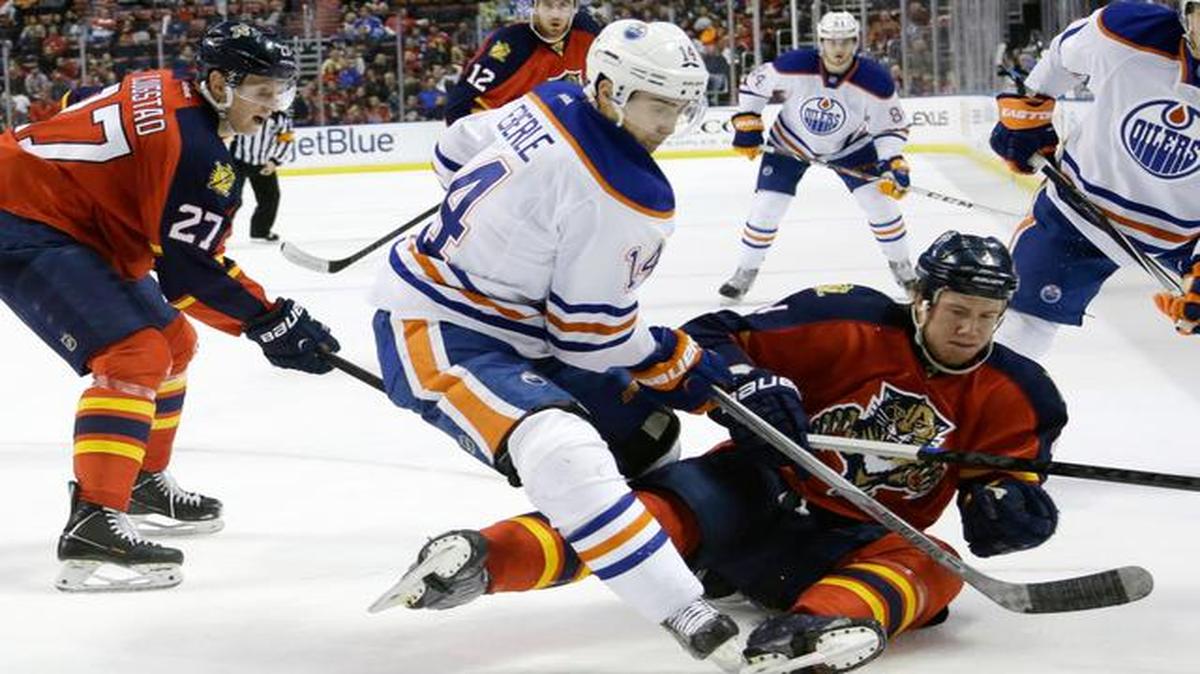 
Edmonton Oilers right wing Jordan Eberle (14) and Florida Panthers defenseman Dylan Olsen, right, go for the puck in the first period of an NHL hockey game, Saturday, Jan. 17, 2015, in Sunrise, Fla. At left is Florida Panthers center Nick Bjugstad (27).
