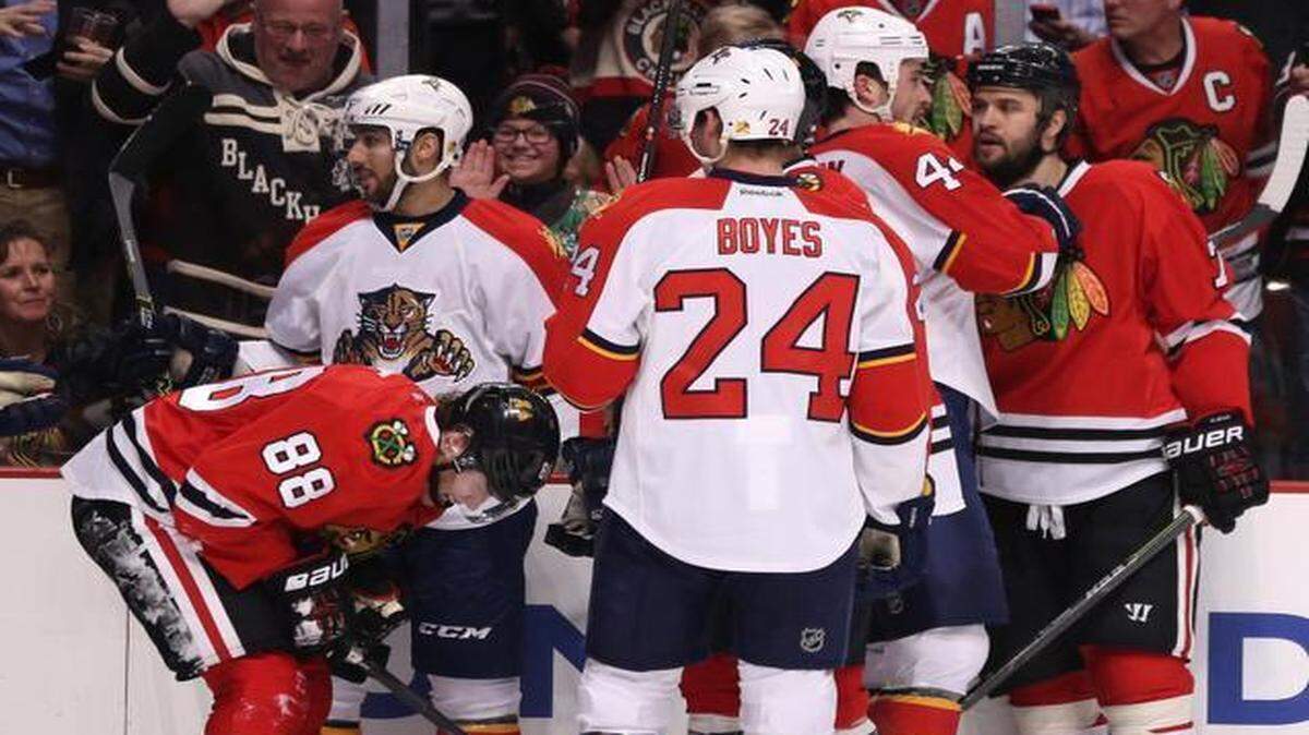 
Chicago Blackhawks right wing Patrick Kane (88) suffers an injury after a cross check by Florida Panthers defenseman Alex Petrovic (72) during the first period on Tuesday, Feb. 24, 2015, at the United Center in Chicago.
