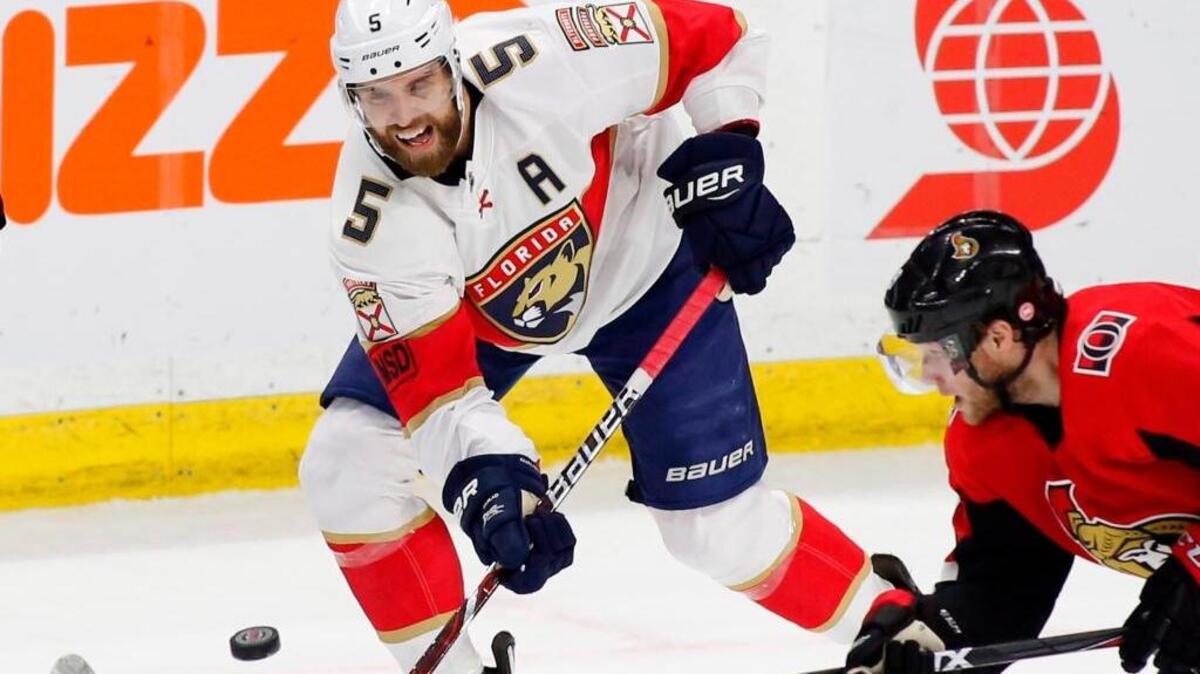 Florida Panthers defenseman Aaron Ekblad (5) shoots the puck past Ottawa Senators right wing Bobby Ryan (9) during the second period of an NHL hockey game on Thursday, March 29, 2018, in Ottawa, Ontario.