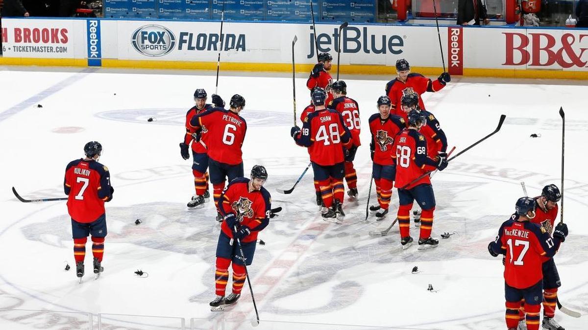 The Florida Panthers gather at center ice and raise their sticks as fans throw plastic rats onto the ice after their win against the Minnesota Wild on Sunday, Jan. 3, 2016, in Sunrise, Fla.