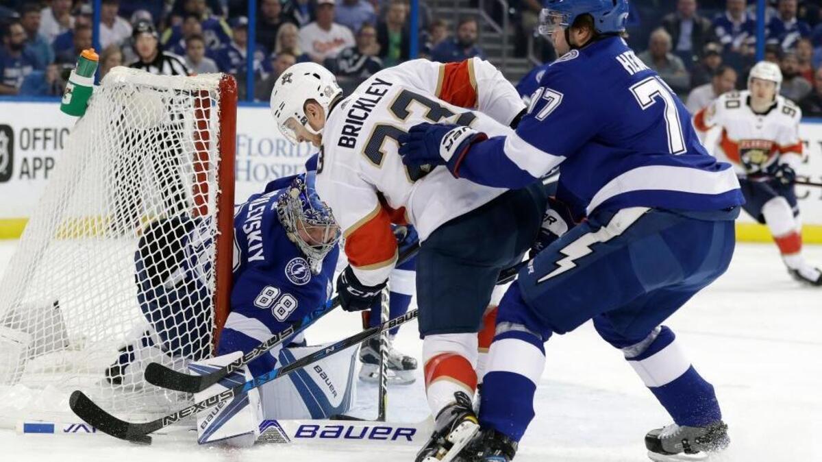 Florida Panthers center Connor Brickley (23) tries to stuff the puck past Tampa Bay Lightning goaltender Andrei Vasilevskiy, (88), of Russia, as defenseman Victor Hedman, (77), of Sweden, defends during the first period of an NHL hockey game Tuesday, March 6, 2018, in Tampa, Fla.