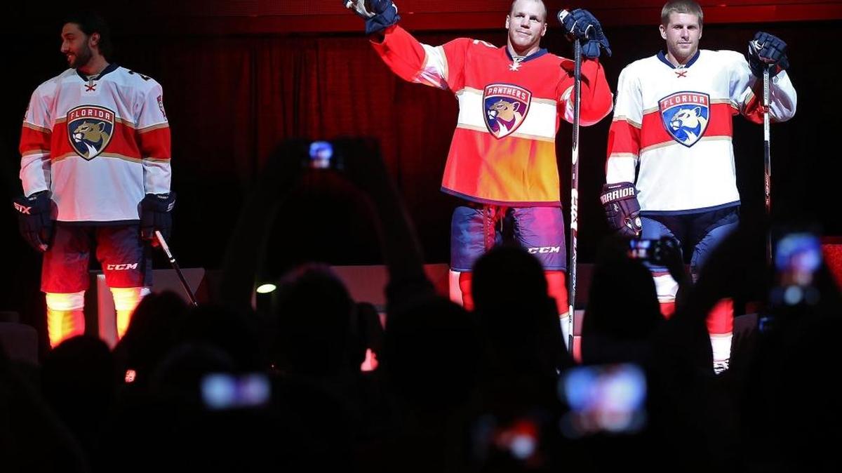 Shawn Thornton, center, models the Florida Panthers’ new uniforms at BB&T Center in Sunrise. Thornton is flanked by Vincent Trocheck (left) and Steven Kampfer.