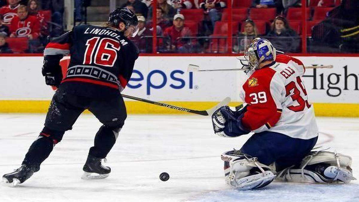 
Carolina Hurricanes’ Elias Lindholm has his shot blocked by Florida Panthers goalie Dan Ellis during the second period Saturday, March 14, 2015, in Raleigh, N.C. 
