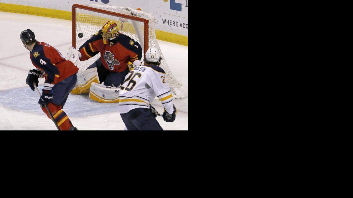 
Florida Panthers goalie Roberto Luongo (1) makes a first period save as teammate Dylan Olsen (4) and Buffalo Sabres left wing Matt Moulson (26) look on during the first period of an NHL hockey game, Saturday, Dec. 6, 2014, in Sunrise, Fla. 
