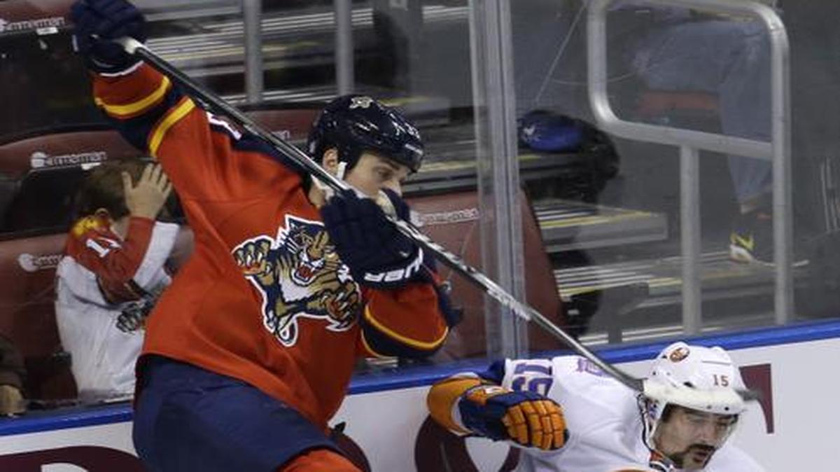 
Florida Panthers defenseman Willie Mitchell, left, and New York Islanders right wing Cal Clutterbuck (15) collide in the second period of an NHL hockey game, Friday, Nov. 14, 2014, in Sunrise, Fla. 
