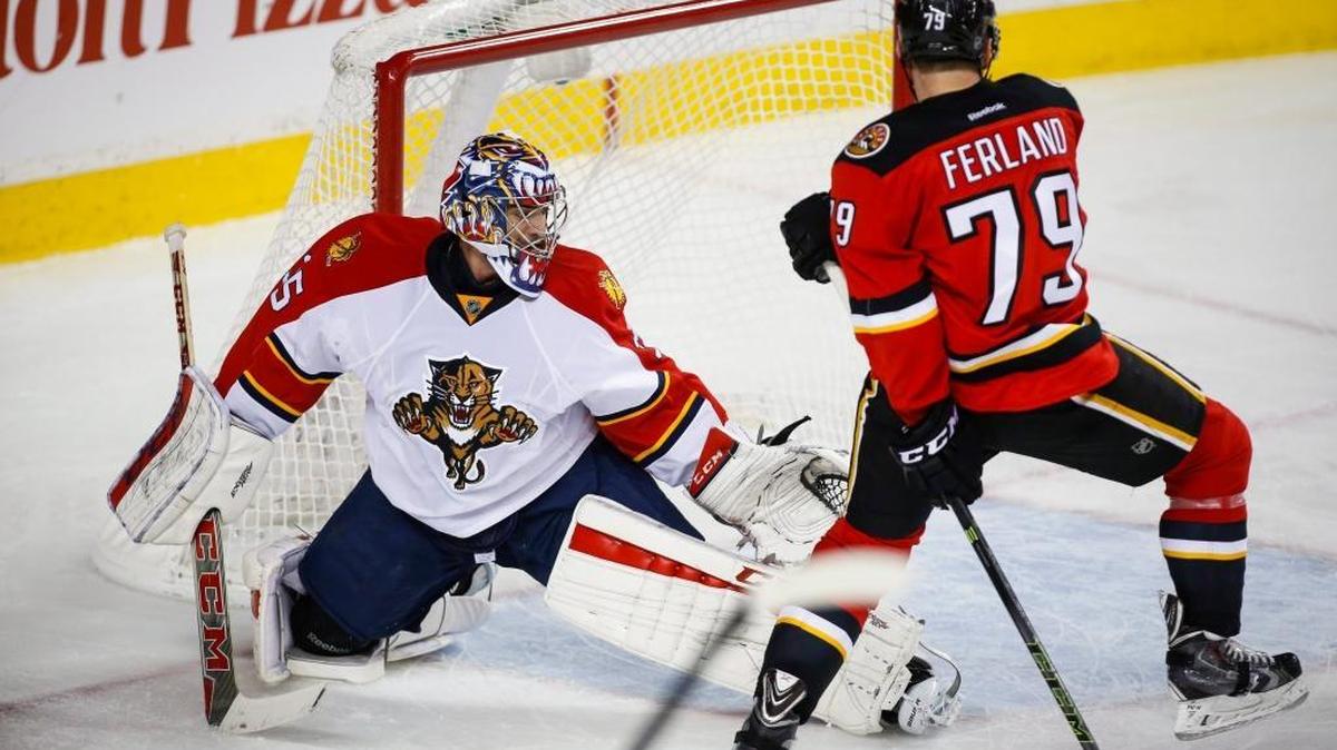 Florida Panthers goalie Al Montoya, left, kicks the puck away from Calgary Flames' Michael Ferland during the third period of an NHL hockey game Wednesday, Jan. 13, 2016, in Calgary, Alberta.