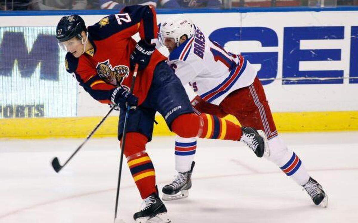 
The Panthers’ Nick Bjugstad, left, fights for the puck with the Rangers’ Derick Brassard.
