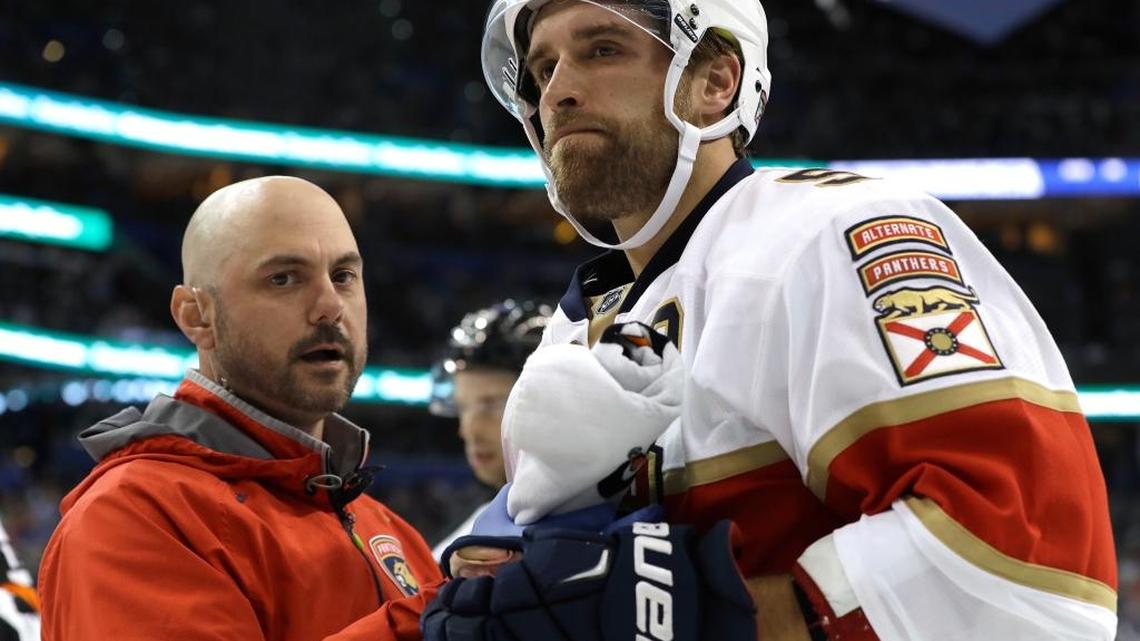 Florida defenseman Aaron Ekblad is looked at by trainer Dave DiNapoli after getting run into the boards by Tampa Bay Lightning center Gabriel Dumont during the second period Saturday.