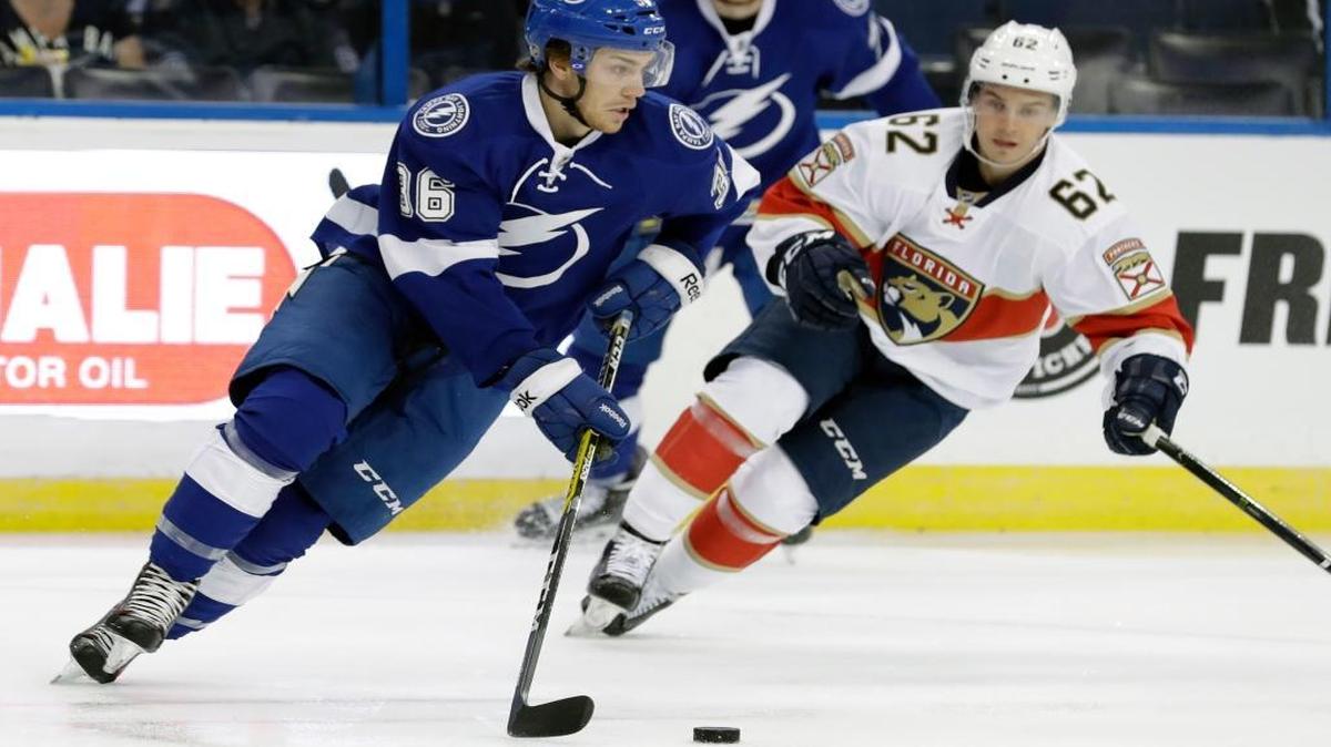 Tampa Bay Lightning center Brayden Point moves the puck around Florida Panthers forward Denis Malgin during a preseason game last September.